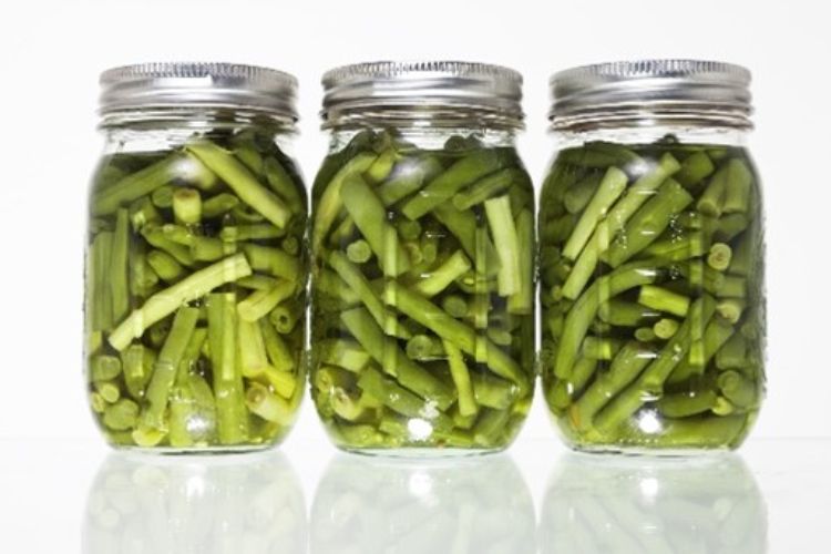 Preserved green beans in three jars.