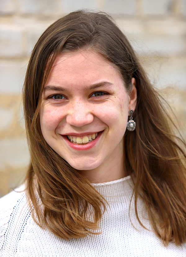 Emma Brinks standing in front of a brick building